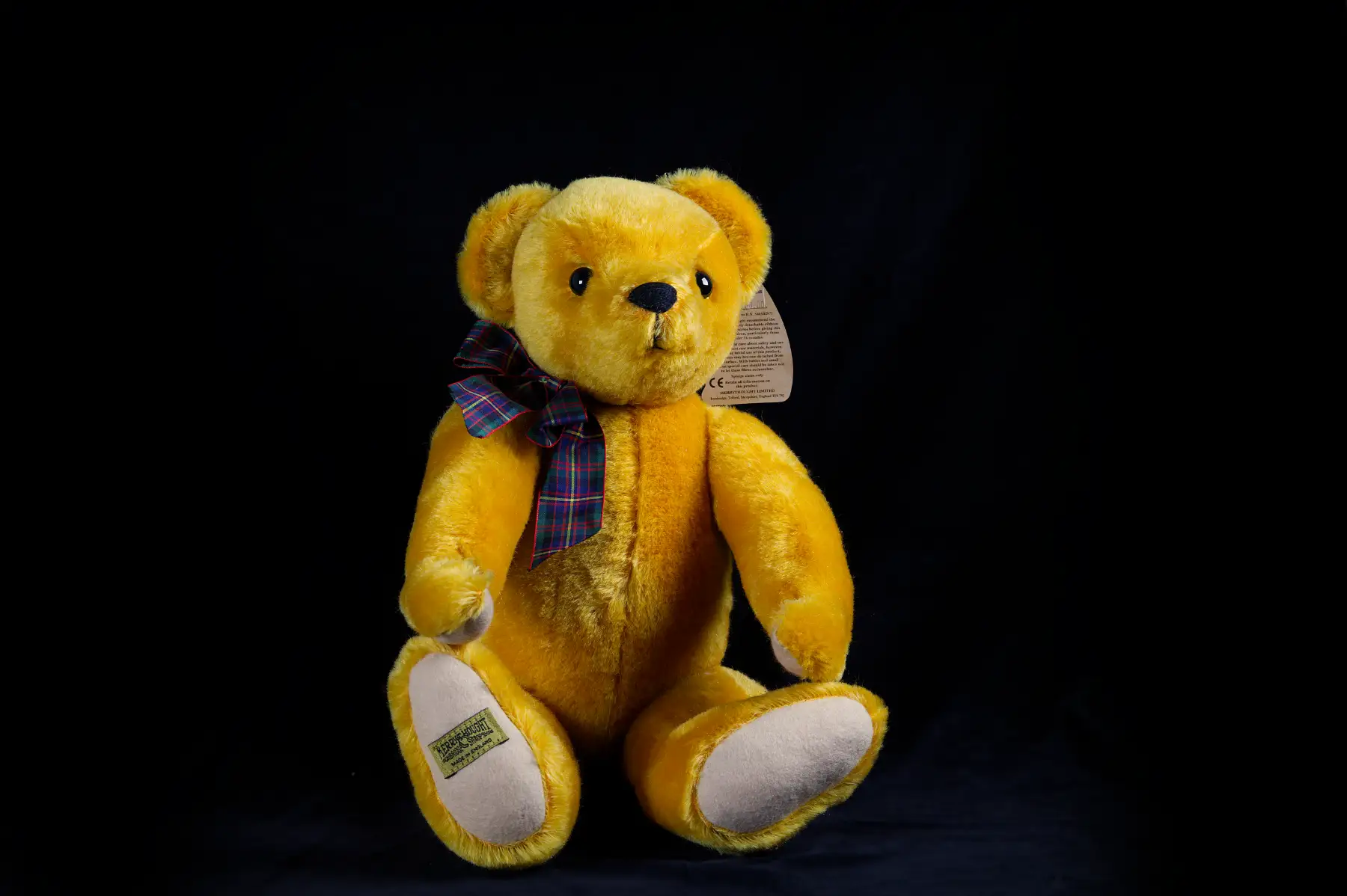 Golden mohair collector teddy bear on black